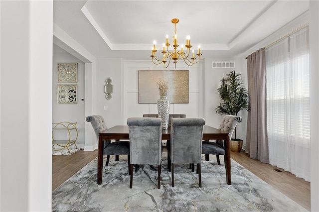 4820 NE 90th Ter, Kansas City, MO 64156 - dining room featuring a chandelier, a raised ceiling, and wood finished floors