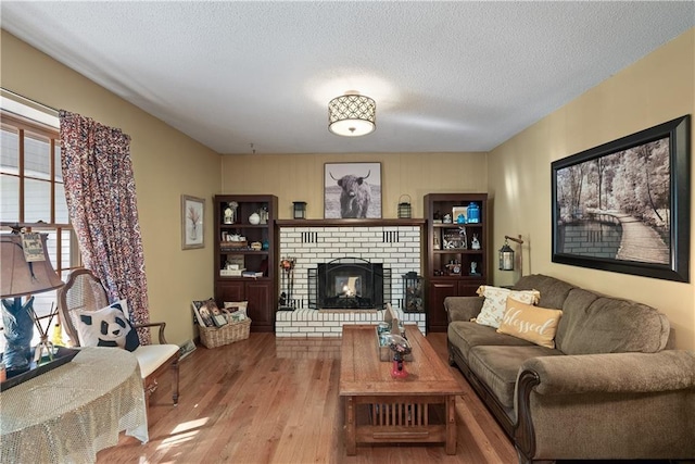 513 Brown Circle Dr, Osawatomie, KS 66064 - living area featuring wood finished floors, a textured ceiling, and a brick fireplace