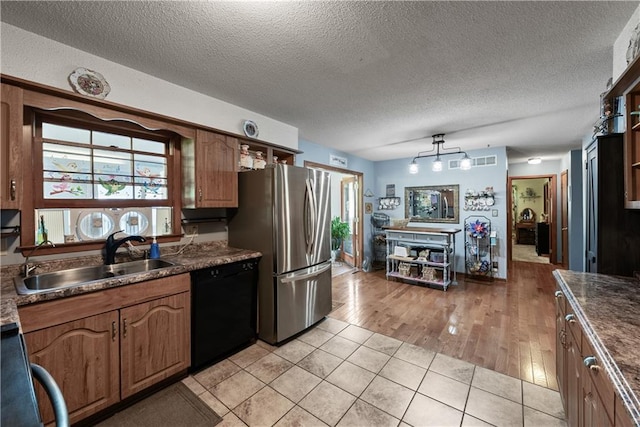 513 Brown Circle Dr, Osawatomie, KS 66064 - kitchen featuring dishwasher, freestanding refrigerator, dark countertops, range, and a textured ceiling