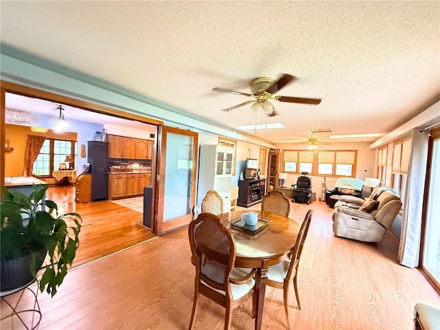 513 Brown Circle Dr, Osawatomie, KS 66064 - dining room with light wood-type flooring, a textured ceiling, and ceiling fan