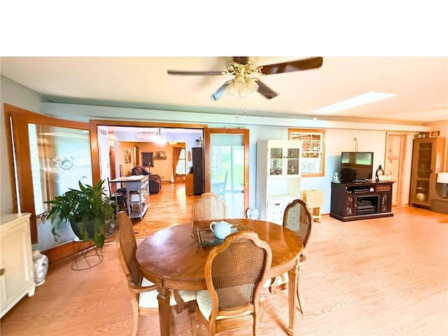 513 Brown Circle Dr, Osawatomie, KS 66064 - dining area with light wood-type flooring, a ceiling fan, and a skylight