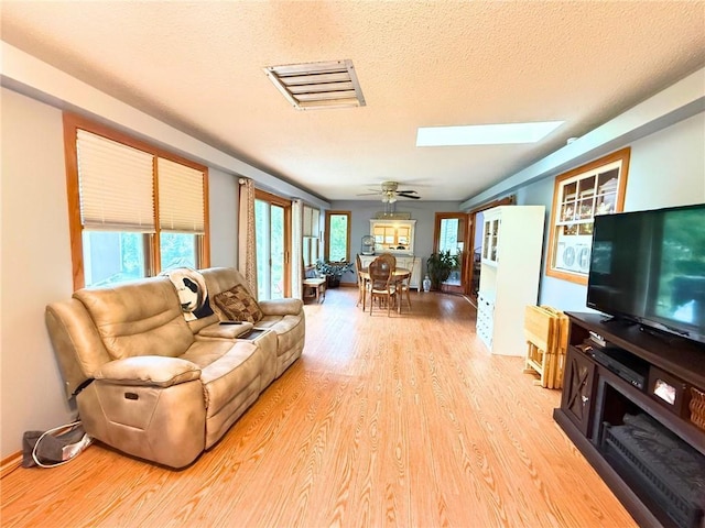 513 Brown Circle Dr, Osawatomie, KS 66064 - living area featuring a skylight, light wood-style flooring, and a textured ceiling