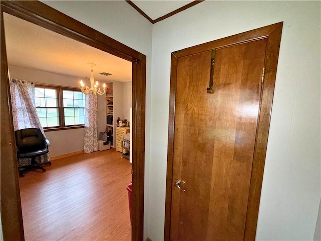 513 Brown Circle Dr, Osawatomie, KS 66064 - hall featuring a chandelier, wood finished floors, and crown molding