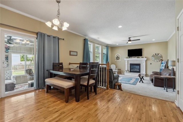 2436 SW Current Ln, Lees Summit, MO 64082 - dining room with ceiling fan, a glass covered fireplace, plenty of natural light, light wood-type flooring, and crown molding