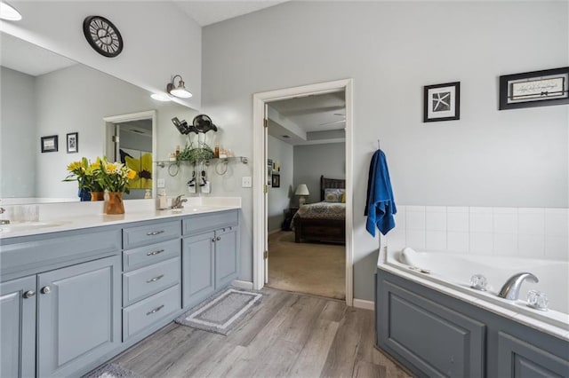 2436 SW Current Ln, Lees Summit, MO 64082 - bathroom featuring wood finished floors, ensuite bath, double vanity, and a bath