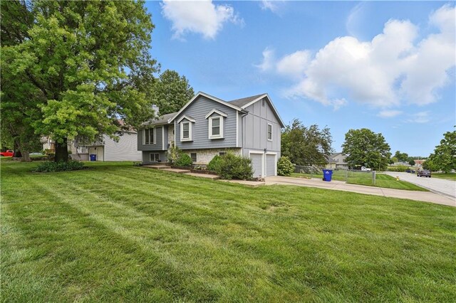 1453 Madison St, Lees Summit, MO 64081 - raised ranch featuring board and batten siding, driveway, an attached garage, and a front lawn