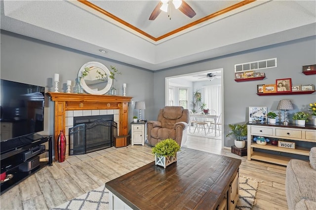 1453 Madison St, Lees Summit, MO 64081 - living area featuring a ceiling fan, wood finished floors, a tray ceiling, and a fireplace