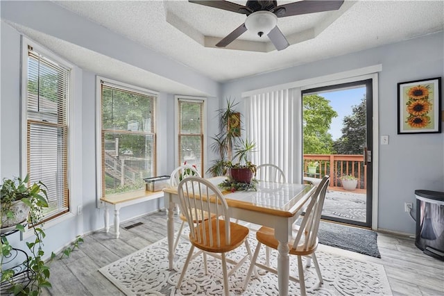 1453 Madison St, Lees Summit, MO 64081 - dining area featuring a textured ceiling, light wood-style floors, a ceiling fan, and baseboards