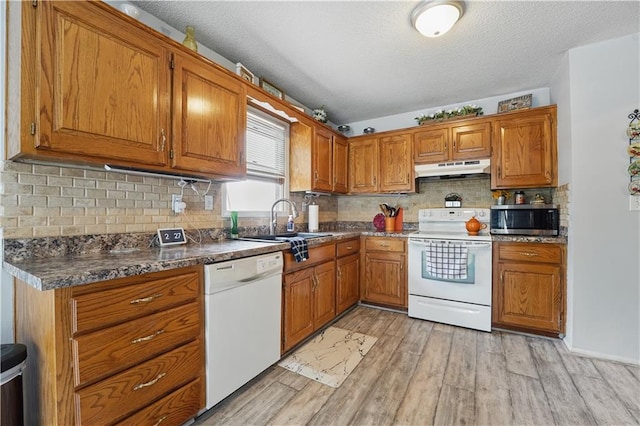1453 Madison St, Lees Summit, MO 64081 - kitchen featuring white appliances, a sink, under cabinet range hood, brown cabinets, and a textured ceiling