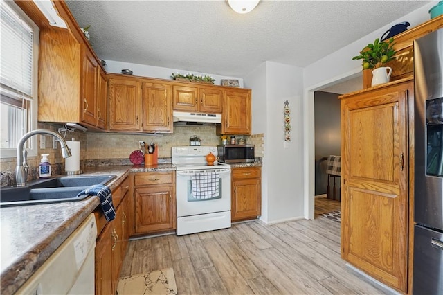 1453 Madison St, Lees Summit, MO 64081 - kitchen with stainless steel appliances, under cabinet range hood, a sink, light wood-type flooring, and brown cabinetry