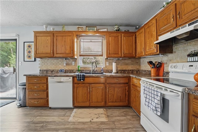 1453 Madison St, Lees Summit, MO 64081 - kitchen featuring white appliances, a sink, a textured ceiling, under cabinet range hood, and brown cabinetry