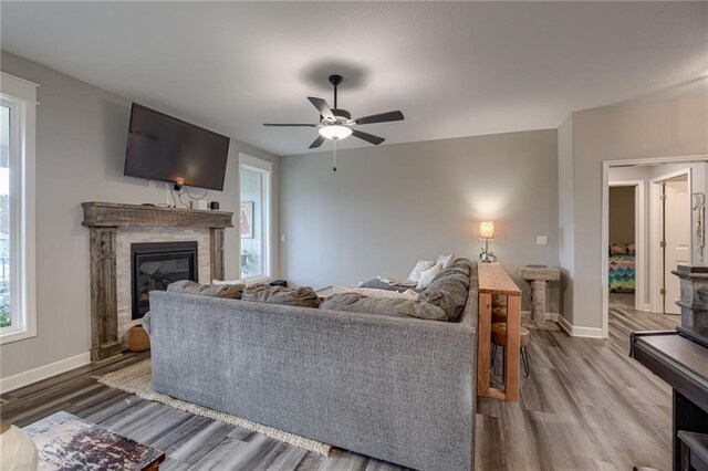 807 N Whispering Hills Dr, Lone Jack, MO 64070 - living area with a glass covered fireplace, wood finished floors, baseboards, and a ceiling fan