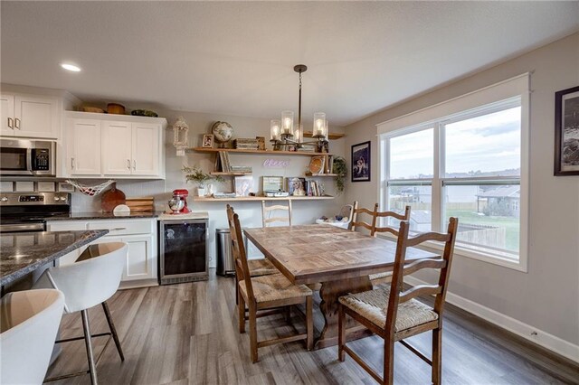 807 N Whispering Hills Dr, Lone Jack, MO 64070 - dining room with beverage cooler, a chandelier, wood finished floors, recessed lighting, and baseboards