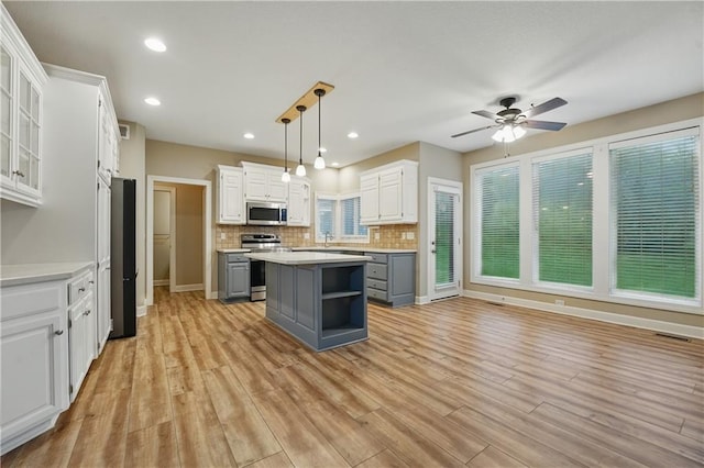 4904 W 162nd St, Overland Park, KS 66085 - kitchen with stainless steel appliances, gray cabinets, white cabinetry, a kitchen island, and a ceiling fan