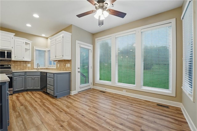 4904 W 162nd St, Overland Park, KS 66085 - kitchen with gray cabinetry, stainless steel appliances, light countertops, ceiling fan, and tasteful backsplash