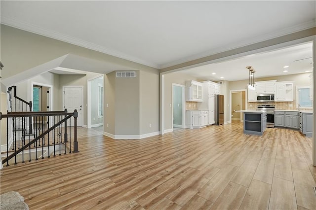 4904 W 162nd St, Overland Park, KS 66085 - unfurnished living room with light wood-style flooring, baseboards, stairs, ornamental molding, and recessed lighting
