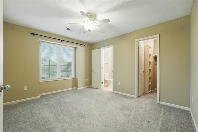 4904 W 162nd St, Overland Park, KS 66085 - unfurnished bedroom with a walk in closet, carpet, ensuite bath, baseboards, and a textured ceiling