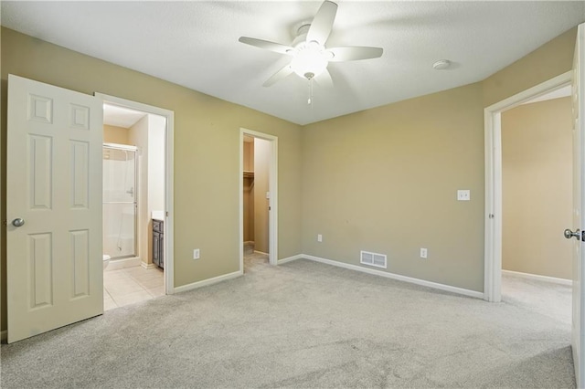 4904 W 162nd St, Overland Park, KS 66085 - unfurnished bedroom featuring light carpet, a walk in closet, baseboards, ensuite bathroom, and a closet