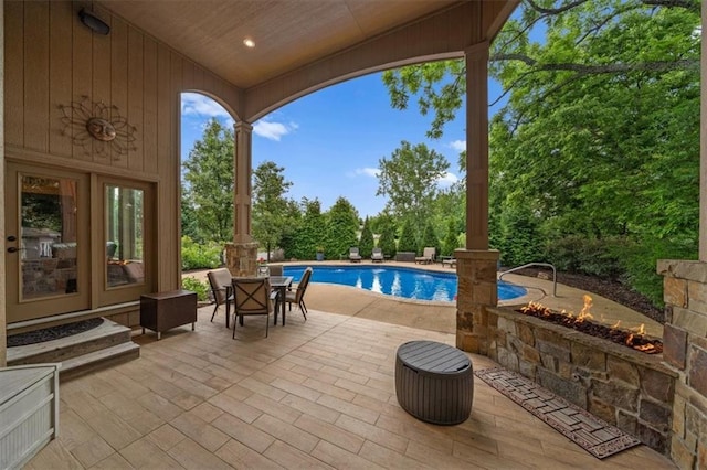 11121 S Whitetail Ln, Olathe, KS 66061 - view of patio featuring an outdoor pool, an outdoor fire pit, and view of wooded area