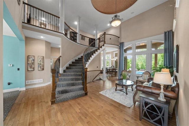 11121 S Whitetail Ln, Olathe, KS 66061 - living room with a high ceiling, hardwood / wood-style flooring, and stairs