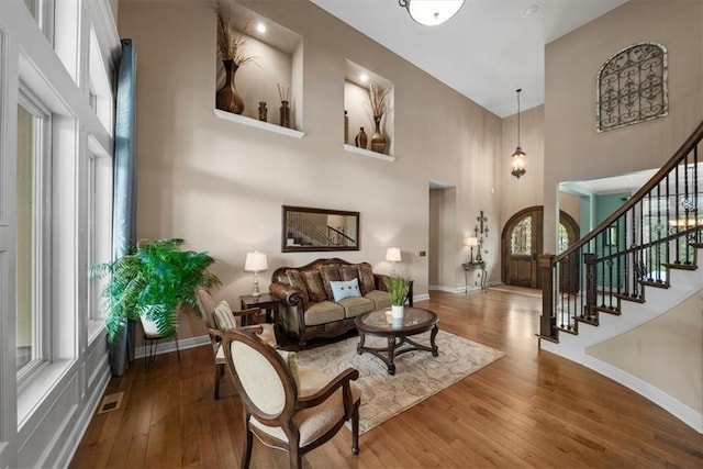 11121 S Whitetail Ln, Olathe, KS 66061 - living room featuring a high ceiling, stairs, and hardwood / wood-style floors