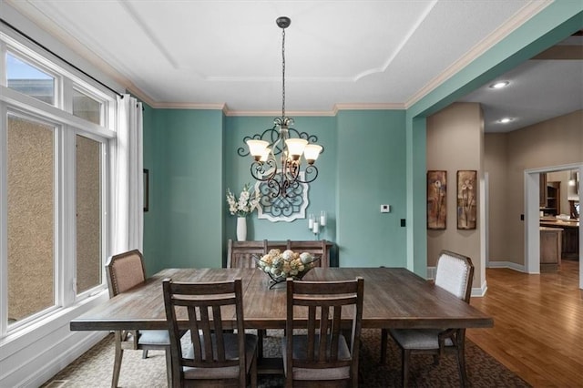 11121 S Whitetail Ln, Olathe, KS 66061 - dining space featuring wood finished floors, a chandelier, a tray ceiling, and crown molding