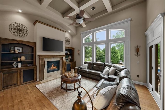 11121 S Whitetail Ln, Olathe, KS 66061 - living area with coffered ceiling, a fireplace, a ceiling fan, light wood finished floors, and beam ceiling