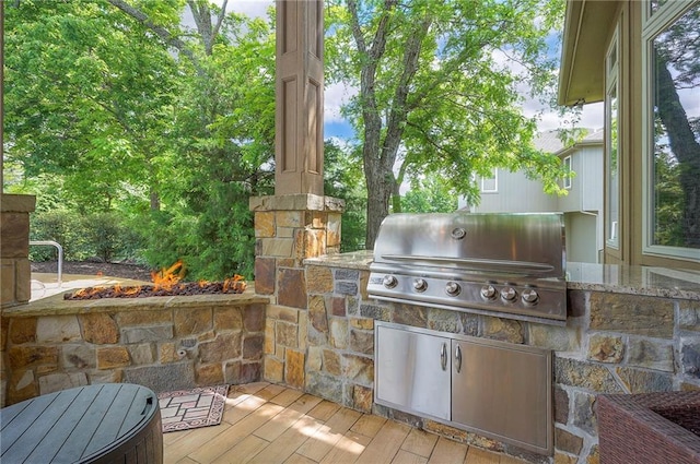 11121 S Whitetail Ln, Olathe, KS 66061 - view of patio / terrace with an outdoor fire pit, exterior kitchen, and a deck