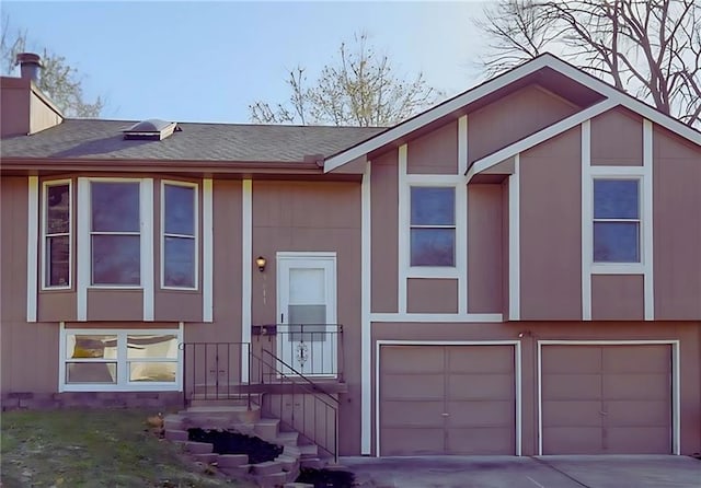 5011 N Elmwood Ave, Kansas City, MO 64119 - raised ranch with a garage, driveway, roof with shingles, and a chimney
