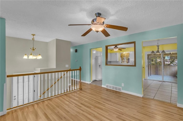 531 S Oak St, Gardner, KS 66030 - unfurnished room featuring wood finished floors, a textured ceiling, baseboards, and a chandelier