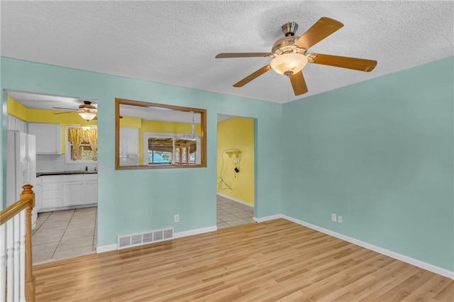 531 S Oak St, Gardner, KS 66030 - empty room with ceiling fan, a textured ceiling, light wood-type flooring, and baseboards