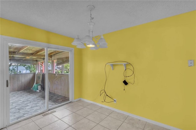 531 S Oak St, Gardner, KS 66030 - unfurnished dining area with a chandelier, light tile patterned floors, baseboards, and a textured ceiling