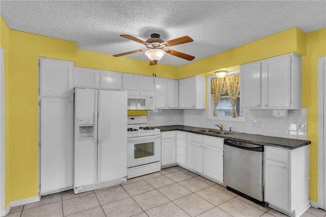 531 S Oak St, Gardner, KS 66030 - kitchen featuring white appliances, a sink, dark countertops, a ceiling fan, and white cabinetry