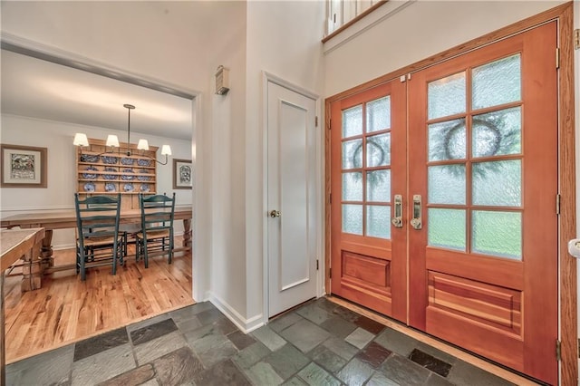 8911 W 105th Ter, Overland Park, KS 66212 - entryway featuring french doors, baseboards, a chandelier, and dark stone finish floors