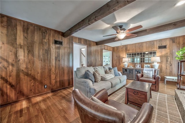 8911 W 105th Ter, Overland Park, KS 66212 - living area with wooden walls, beam ceiling, a ceiling fan, and wood finished floors