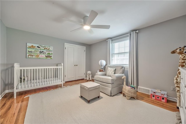 8911 W 105th Ter, Overland Park, KS 66212 - bedroom featuring wood finished floors, a ceiling fan, a nursery area, a closet, and baseboards