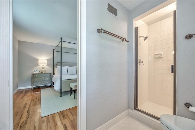 8911 W 105th Ter, Overland Park, KS 66212 - ensuite bathroom featuring a shower stall, toilet, wood finished floors, and baseboards