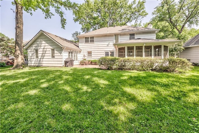 8911 W 105th Ter, Overland Park, KS 66212 - back of house with a sunroom, a chimney, and a lawn
