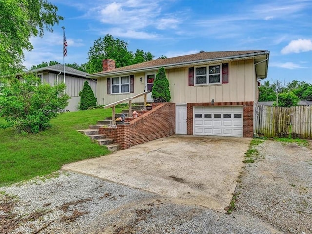 610 Morgan St, Lansing, KS 66043 - view of front facade with concrete driveway, an attached garage, a chimney, and brick siding