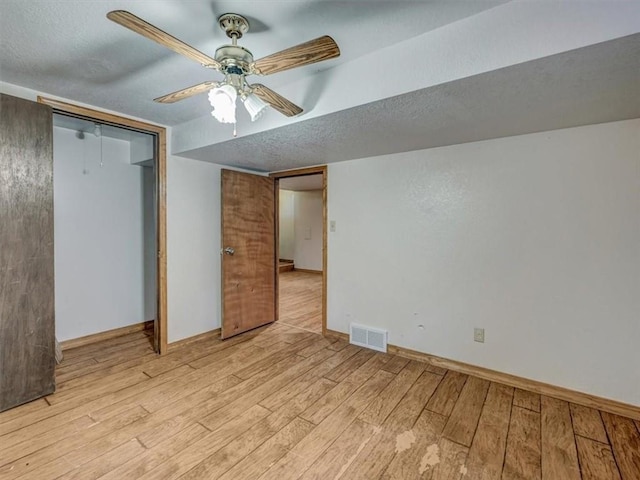 610 Morgan St, Lansing, KS 66043 - unfurnished bedroom featuring light wood-style floors, a textured ceiling, a closet, baseboards, and ceiling fan