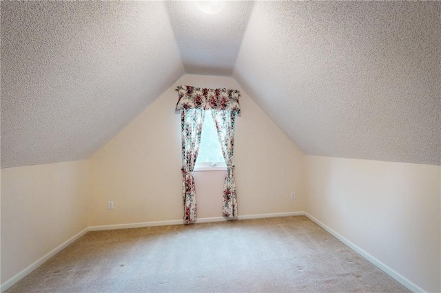 1404 NE Piedmont Dr, Lees Summit, MO 64064 - bonus room featuring a textured ceiling, carpet, vaulted ceiling, and baseboards