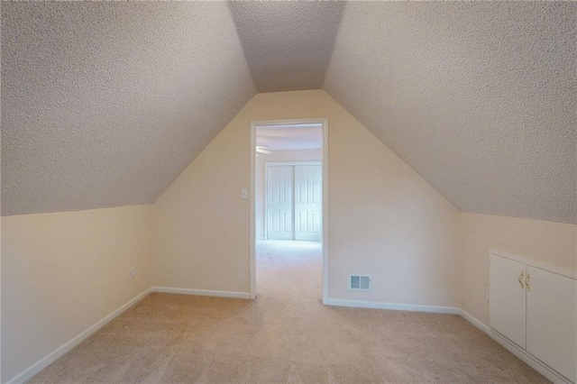 1404 NE Piedmont Dr, Lees Summit, MO 64064 - bonus room featuring a textured ceiling, light carpet, baseboards, and vaulted ceiling