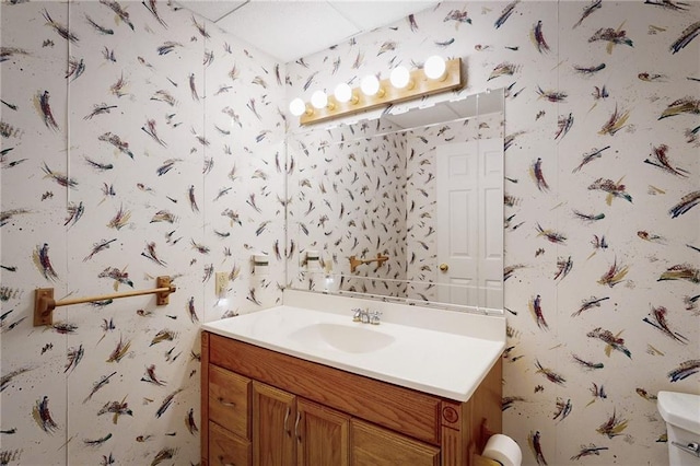 1404 NE Piedmont Dr, Lees Summit, MO 64064 - half bath featuring wallpapered walls, vanity, and toilet