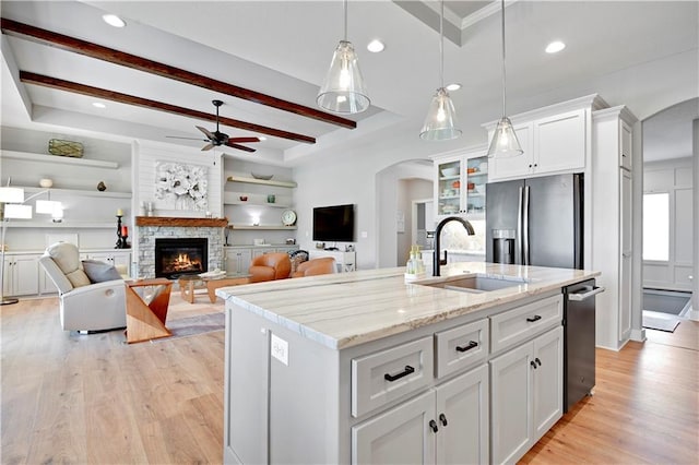 16394 S Loiret St, Olathe, KS 66062 - kitchen with arched walkways, stainless steel refrigerator with ice dispenser, a stone fireplace, ceiling fan, and recessed lighting