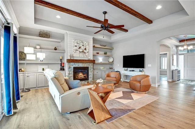 16394 S Loiret St, Olathe, KS 66062 - living area with arched walkways, a stone fireplace, light wood-style flooring, ceiling fan, and beamed ceiling