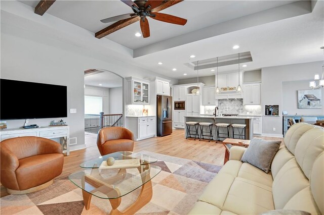 16394 S Loiret St, Olathe, KS 66062 - living area with light wood finished floors, ceiling fan, recessed lighting, arched walkways, and a tray ceiling