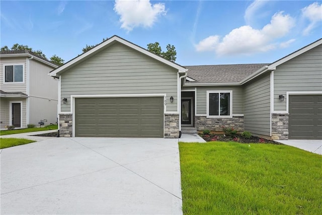 789 Highland Dr, Edwardsville, KS 66111 - view of front of property featuring stone siding, driveway, a front yard, a garage, and a shingled roof