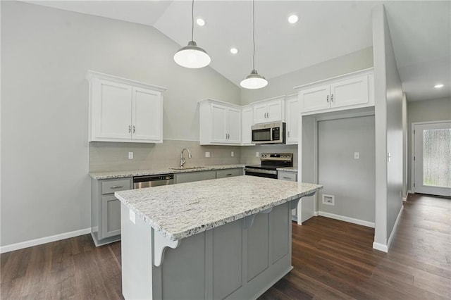 789 Highland Dr, Edwardsville, KS 66111 - kitchen featuring appliances with stainless steel finishes, lofted ceiling, backsplash, white cabinets, and a kitchen island