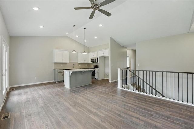 789 Highland Dr, Edwardsville, KS 66111 - kitchen with stainless steel appliances, a kitchen island, open floor plan, white cabinets, and a ceiling fan