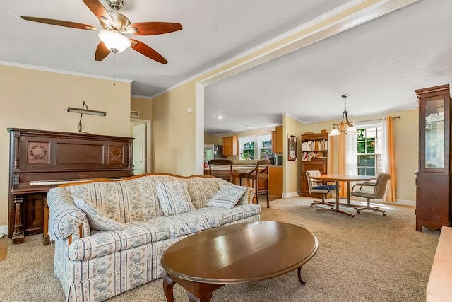 415 E Hulett St, Edgerton, KS 66021 - living room featuring light carpet, ornamental molding, ceiling fan, and baseboards